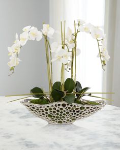 a white flower arrangement in a decorative bowl