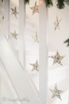 christmas decorations are hanging on the banisters in front of white walls and stairs