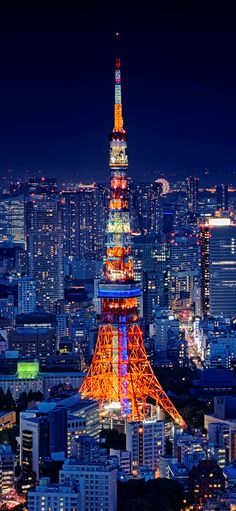 the eiffel tower lit up at night with city lights in the foreground