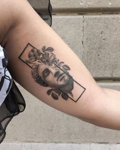 a woman's arm with a black and white portrait tattoo on the left forearm