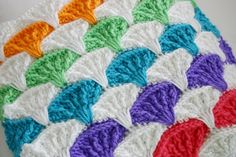 a crocheted blanket with multicolored leaves on it