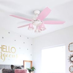 a bed room with a neatly made bed and a pink ceiling fan above the bed