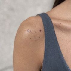 the back of a woman's shoulder with small dots on her left arm and right arm