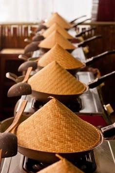 a row of pots and pans with straw hats on them