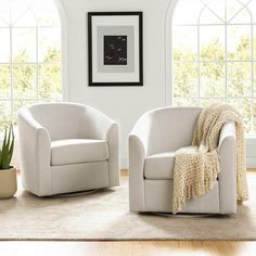 a living room with two white chairs and a potted plant in front of the window