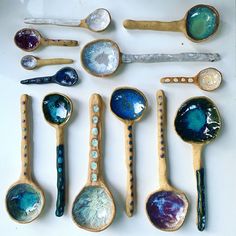 spoons are lined up on a white surface with different colors and designs in them