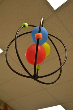 three colorful balloons are hanging from the ceiling