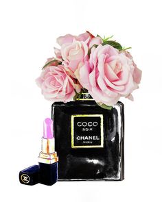 pink roses in a black chanel bag with lipstick and perfume bottle next to it