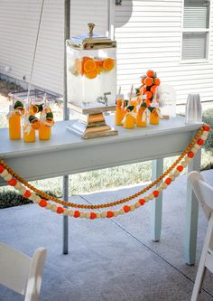 an orange and white dessert table is set up outside