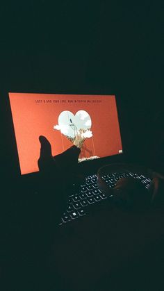 a person is typing on a computer keyboard at night with an elephant image on the screen