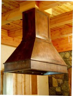 a stove top oven mounted to the side of a wall in a room with wood paneling