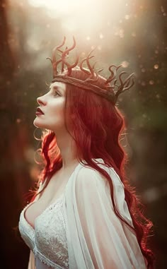 a woman with long red hair wearing a crown and white dress is looking up into the sky