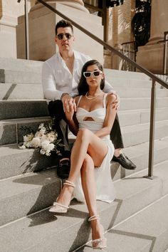 a man and woman sitting on some stairs