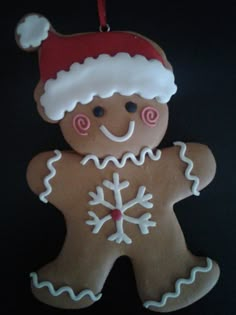 a gingerbread man ornament with a santa hat