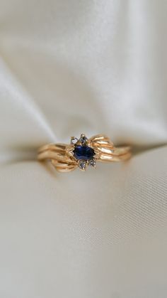 * Ring Material: Blue Sapphire, Diamond, 14K Yellow Gold * Ring Dimensions: 6.7x6.8MM Top Design, 2.3MM Tapering Band * Size: 6.25 * Stone Weight & sizes: Blue Sapphire - 0.13ct, Diamond -0.04ct * Overall weight: 3.7g Midnight Blue Sapphire Ring, 14k Gold Birthstone Cluster Ring, Sapphire 14k Gold Promise Ring, Timeless Blue Rings With Diamond Accents, Sapphire Cluster Ring For Promise, 14k Gold Cluster Ring With Birthstone, Sapphire Rings With Diamond Accents In Cluster Shape, Blue Diamond Ring With 14k Gold Accents, Gold And Sapphire Ring