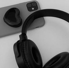 an iphone and headphones sitting next to each other on top of a white table