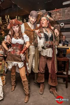 three people dressed in pirate costumes posing for the camera