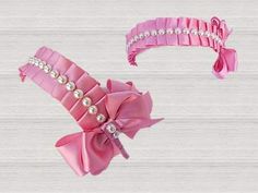 two pink garters with bows and pearls on them, one in the shape of a bow