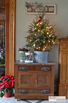 a small christmas tree sitting on top of a wooden cabinet