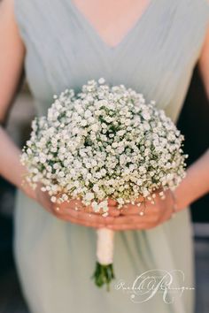 a woman holding a bouquet of flowers in her hands