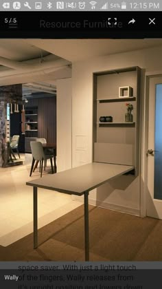 a room with a table, chairs and shelves on the wall in front of it