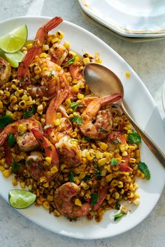 shrimp, corn and lime salad on a white plate with a silver serving utensil