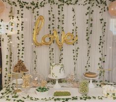 a table topped with lots of desserts and balloons in the shape of words love