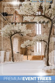 an indoor ceremony with white flowers and trees in the center, surrounded by stone walls