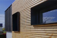 two windows on the side of a building with wood slats in front of them