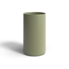 a green cup sitting on top of a white table