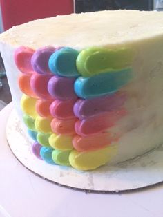 there is a cake decorated with multicolored icing on the top of it