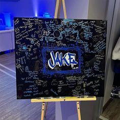 an easel with graffiti written on it in front of a blue wall and floor