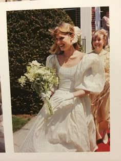 a woman in a white dress is walking down the street with another woman behind her