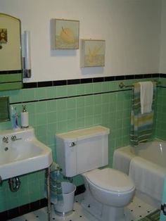 a bathroom with green tiles and white fixtures