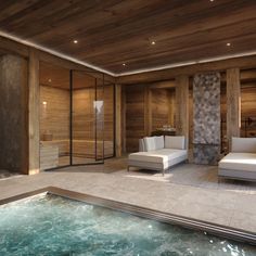 a spa room with a jacuzzi tub and two white couches next to it