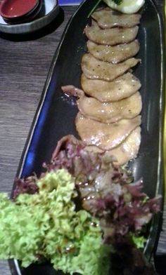 a long black plate with food on it sitting on top of a table next to a banana