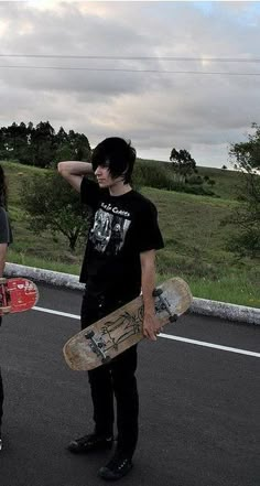 two skateboarders are standing in the street with their boards