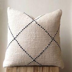 a white pillow sitting on top of a wooden stand