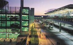 an airport terminal at night with traffic on the road