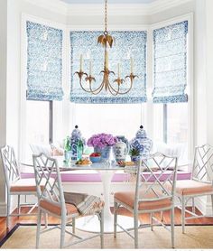 a dining room table with chairs and a chandelier hanging from it's ceiling