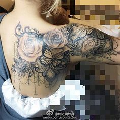 the back of a woman's shoulder with roses and laces on her arm