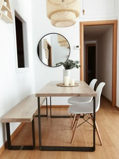 a dining room table with chairs and a mirror on the wall above it that says interest