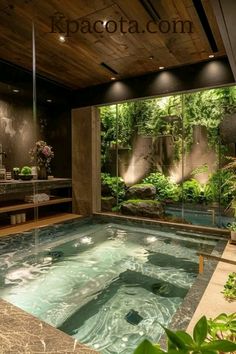 an indoor hot tub in the middle of a room with large windows and plants around it