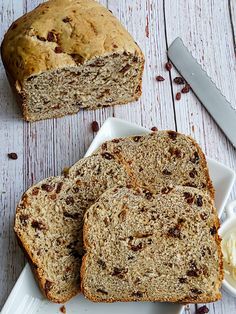 two slices of bread sitting on top of a white plate next to butter and a knife