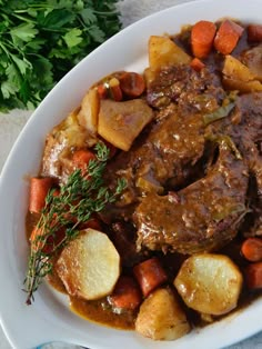 a white plate topped with meat, potatoes and carrots