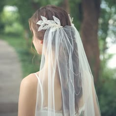 a woman wearing a veil with flowers on the back of her head and hair comb