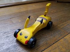 a yellow toy car sitting on top of a wooden floor next to a door way