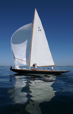 a sailboat with people on it in the water