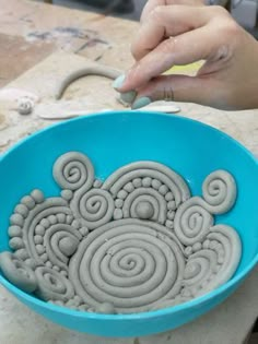 a person is working with clay in a bowl