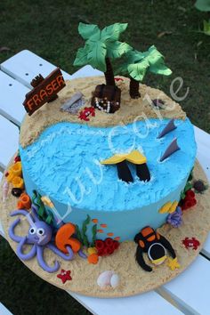 a cake that is sitting on top of a white wooden bench with an ocean theme